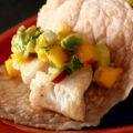 Cassava flour paleo fish tacos, with mango salsa, on a red plate.