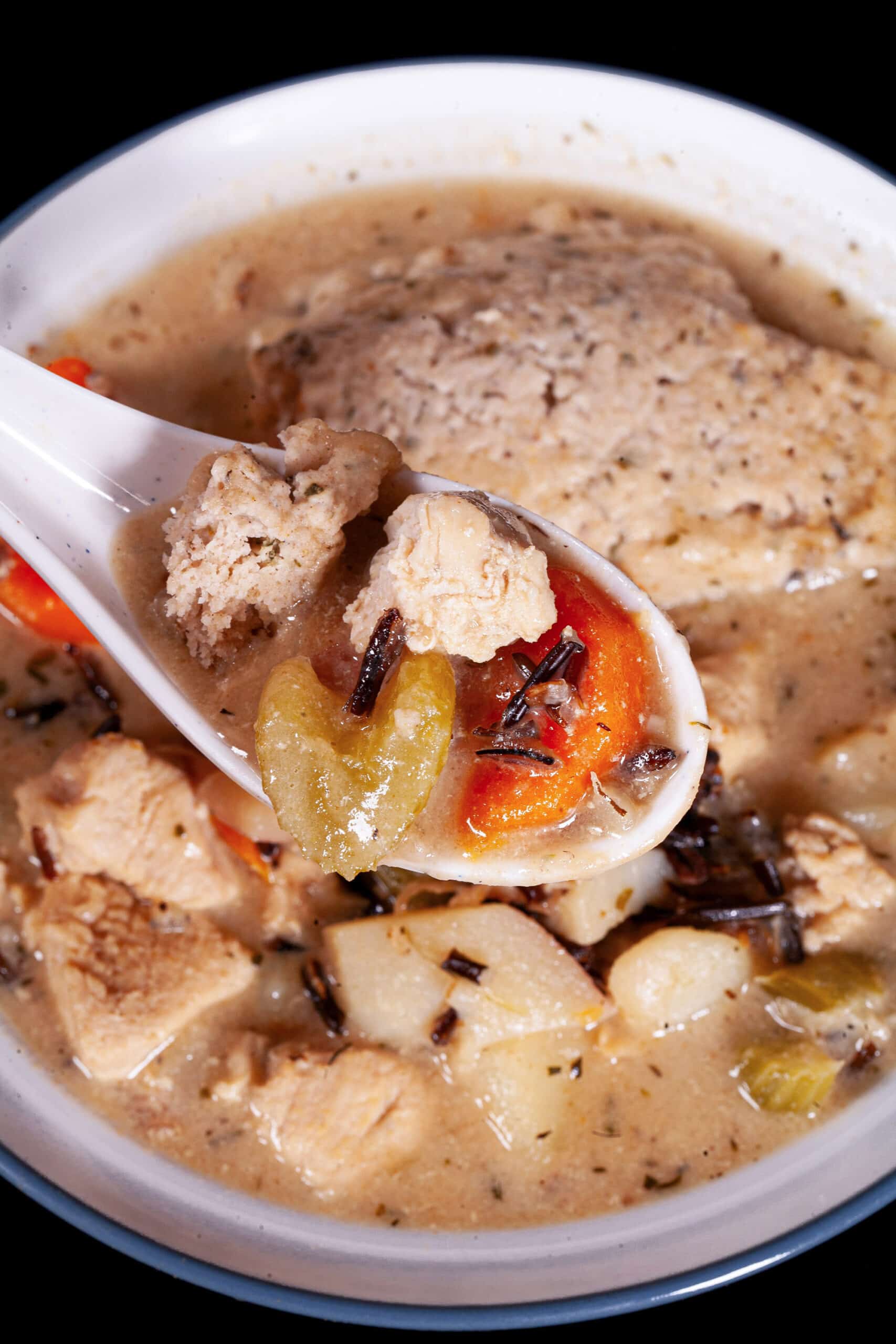 A bowl of gluten free chicken wild rice soup with gluten free dumplings.