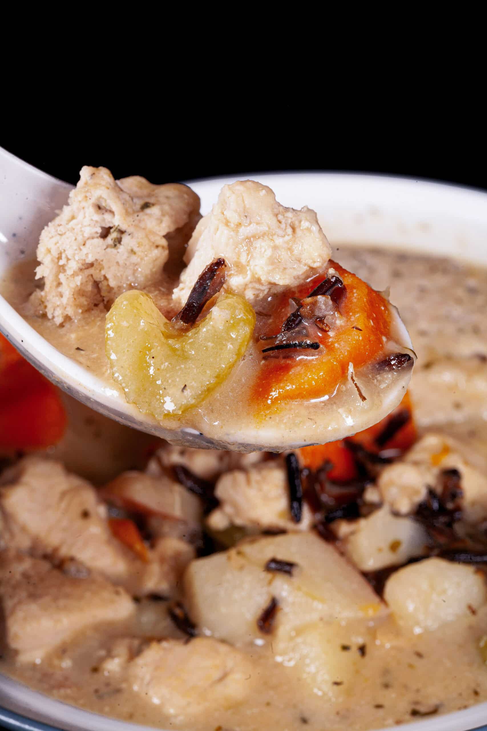 A bowl of gluten free creamy chicken wild rice soup with dumplings.