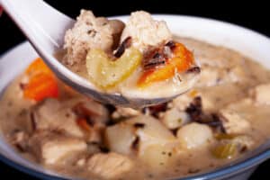 A bowl of gluten free chicken wild rice soup with gluten free dumplings.
