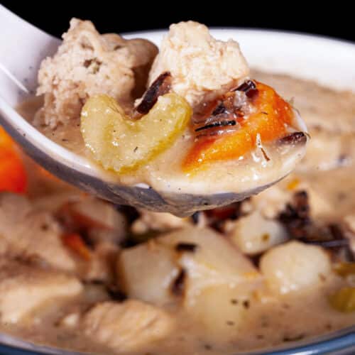 A bowl of gluten free chicken wild rice soup with gluten free dumplings.