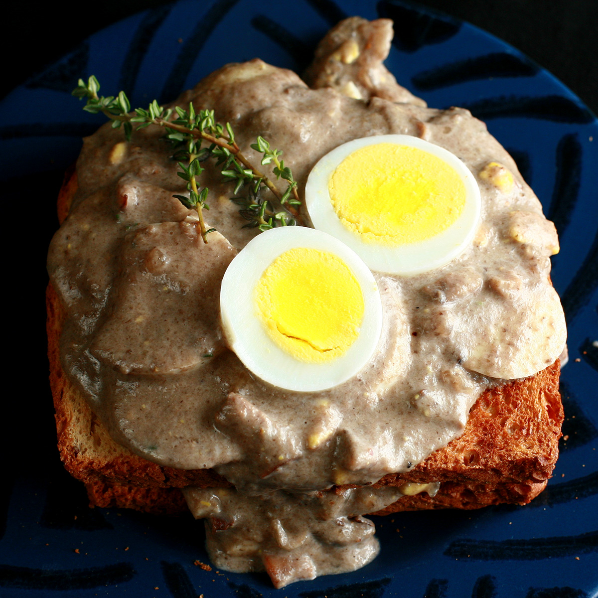 Gluten-Free Mushroom Soup and Eggs on Toast, garnished with hardboiled egg slices and thyme.