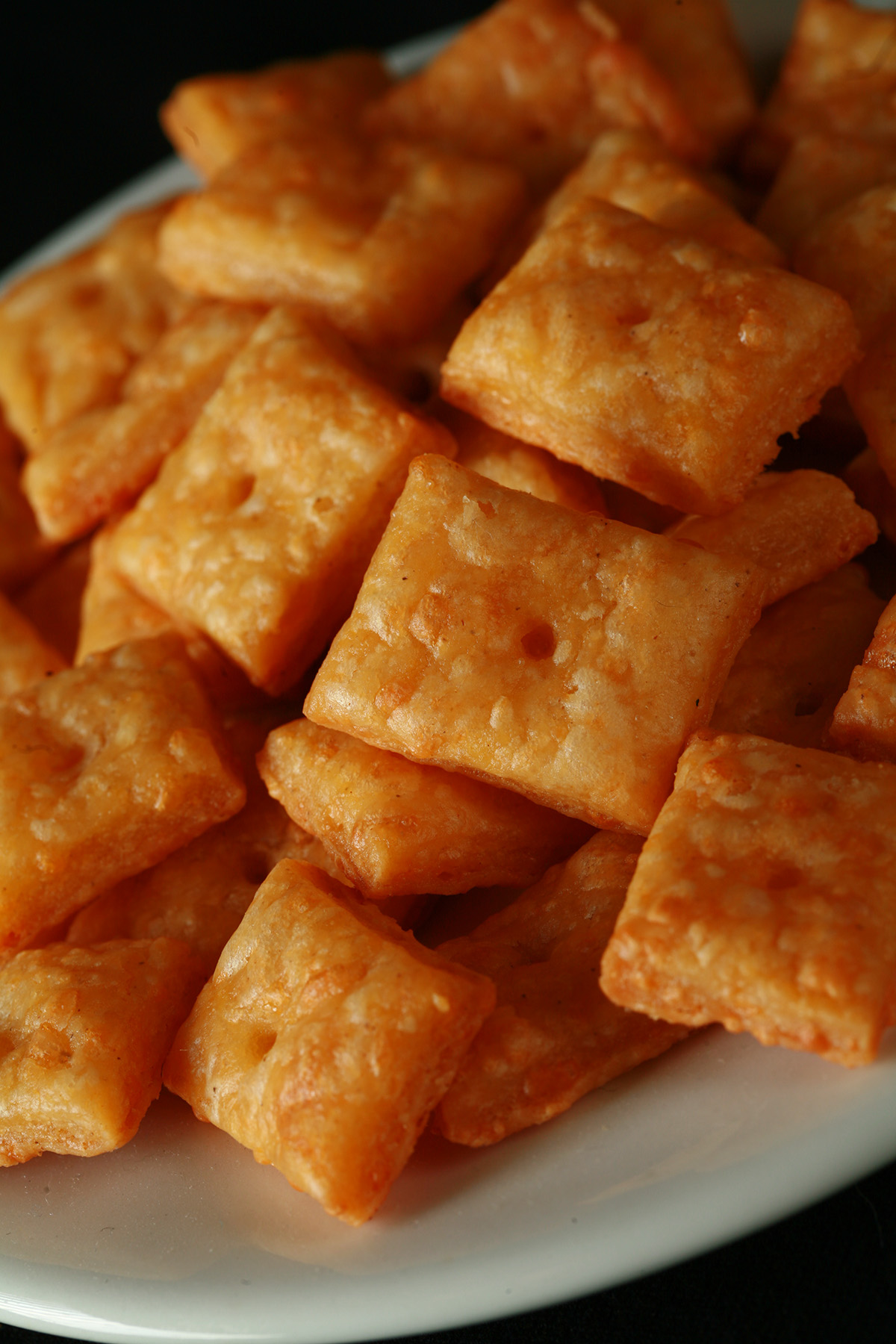 A pile of gluten-Free Cheez-its - little square gluten-free cheese crackers.