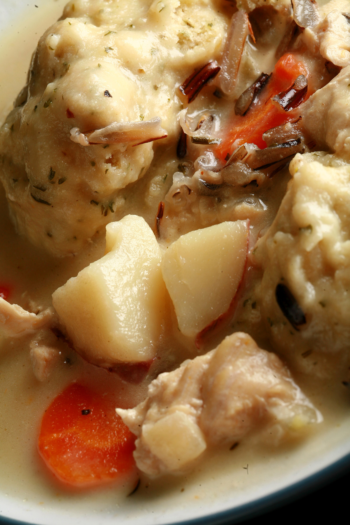 A bowl of gluten-free creamy chicken wild rice soup with dumplings.