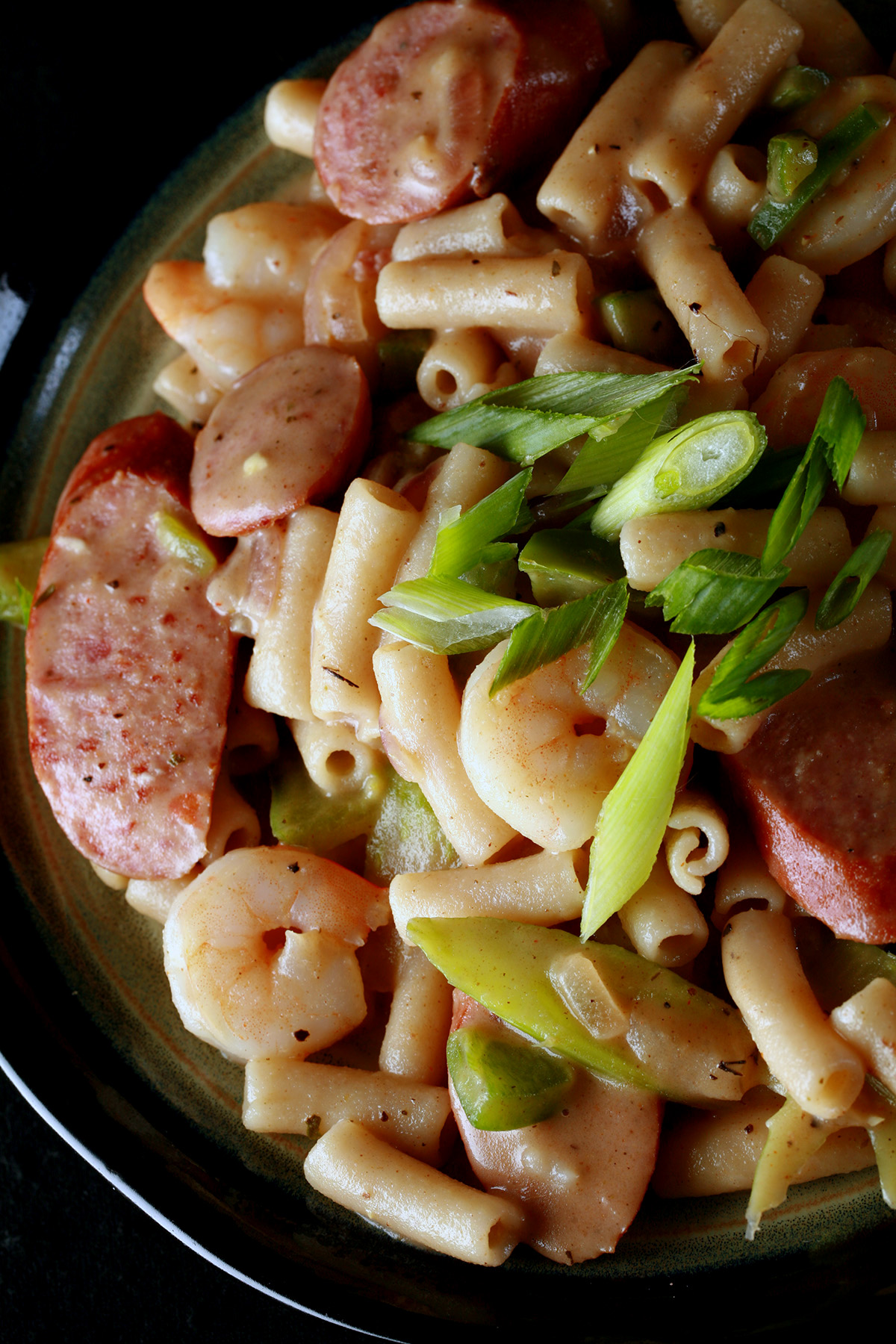 A plate of gluten-Free Creamy Creole Pasta.  Shrimp, chicken, sausage, and celery are visible.
