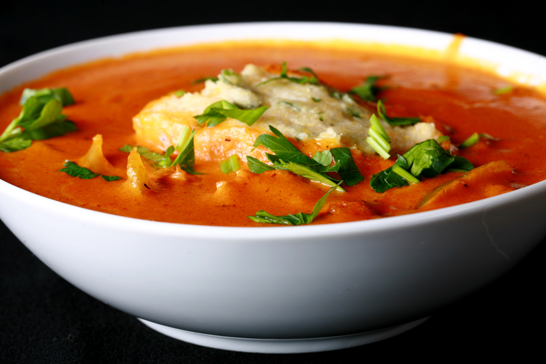 A bowl of gluten-free creamy creole soup with cornmeal dumplings.