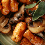 Close up view of AIP sweet potato gnocchi with mushrooms and sage.