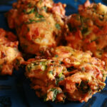 Several Mixed vegetable pakora, on a blue plate.
