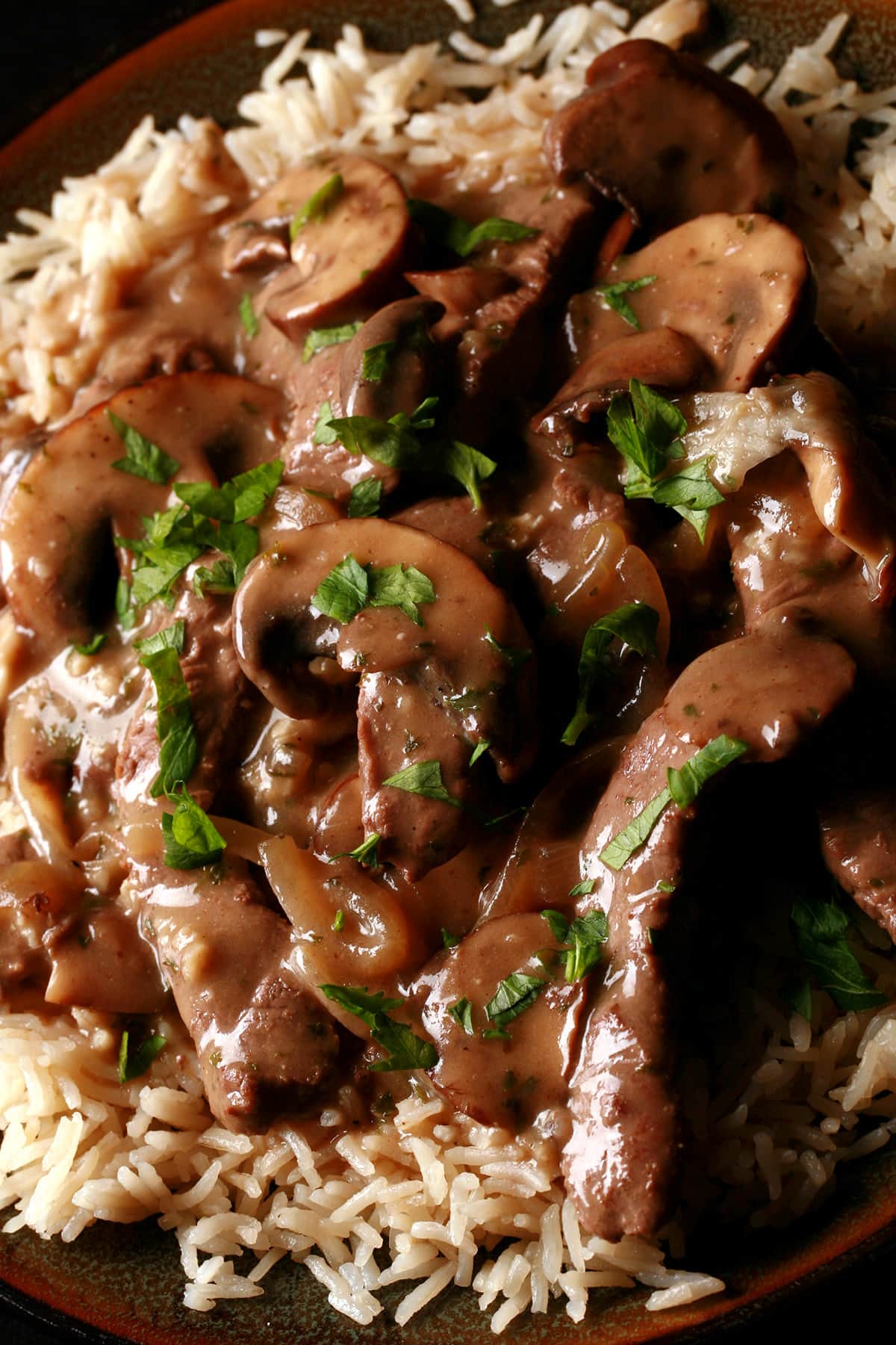 A serving of gluten-free beef stroganoff over a bed of rice.