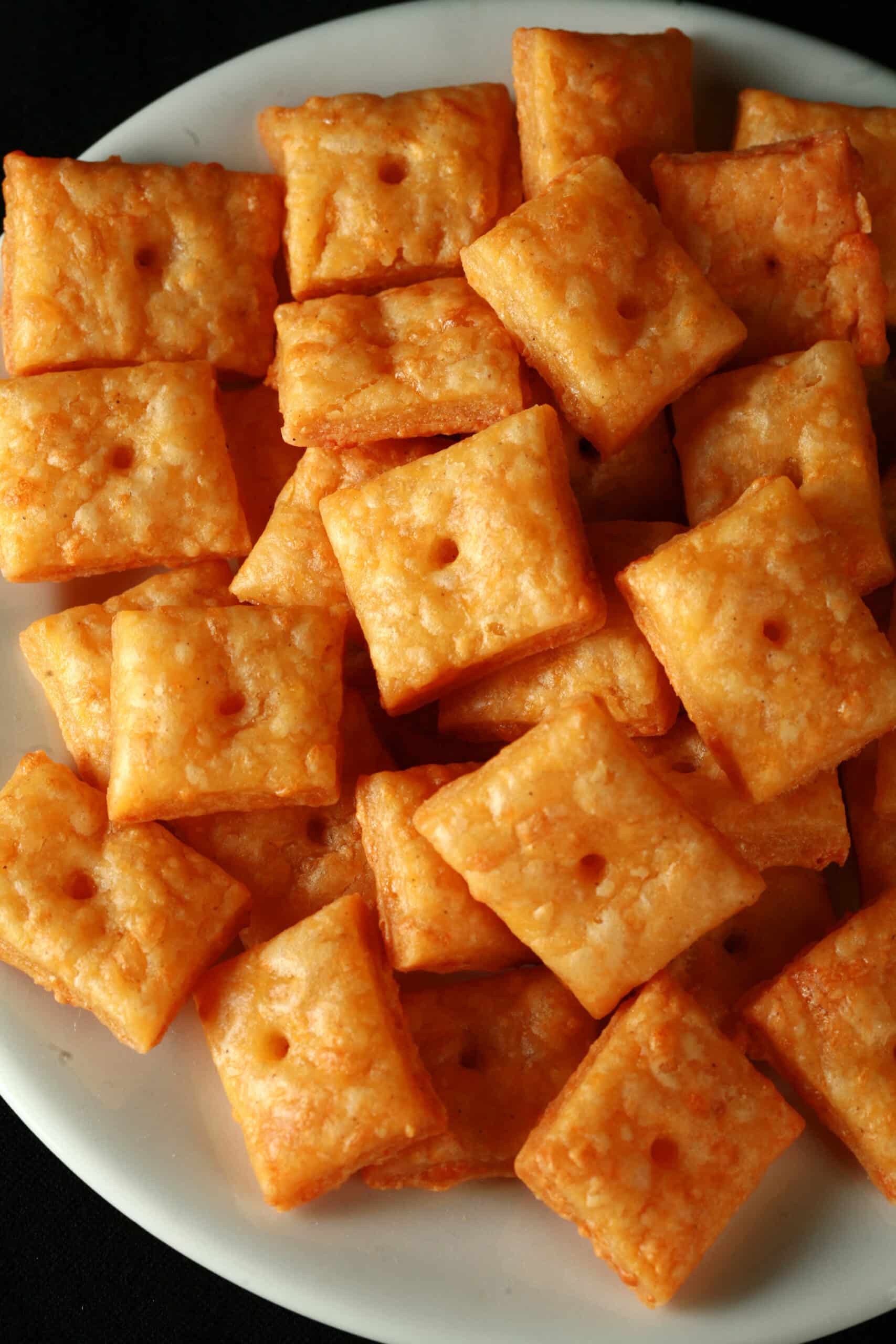 A plate of gluten free cheez its cheese crackers.