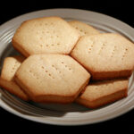 A plate of hexagonal gluten free shortbread cookies.