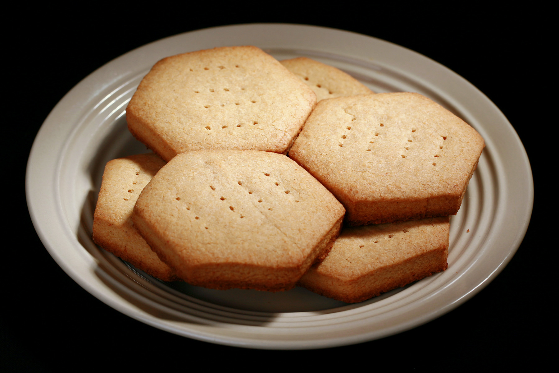 A plate of hexagonal gluten free shortbread cookies.