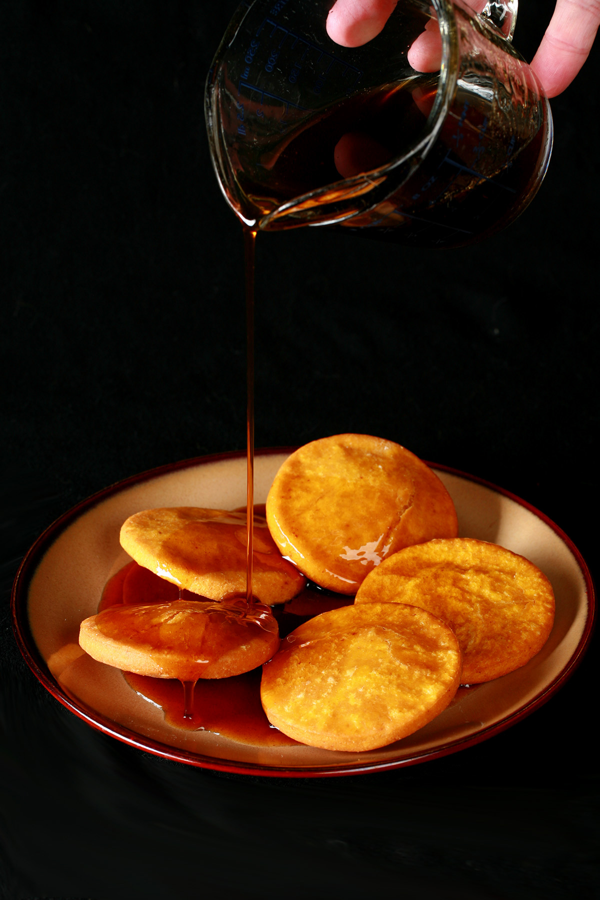 A plate of gluten free sopaipilla pasadas, with sauce drizzled over them.