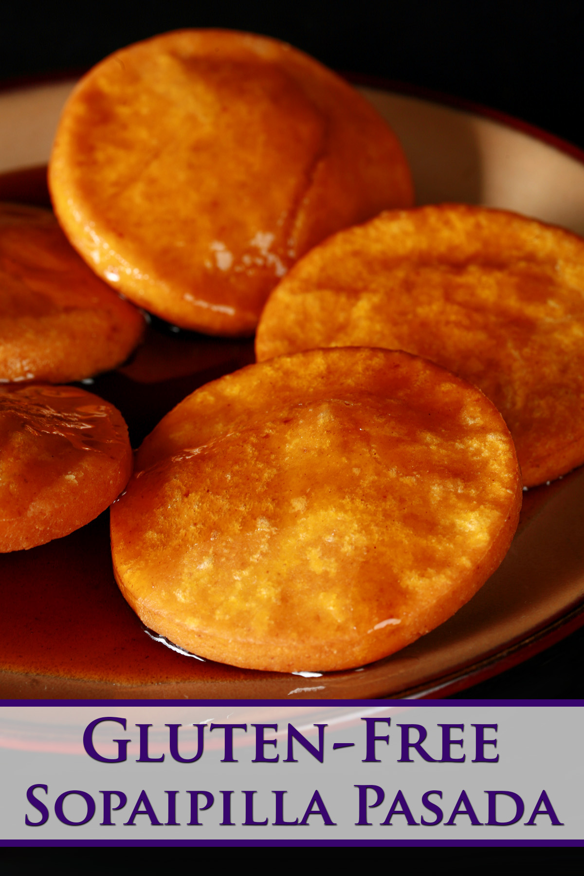 A plate of gluten free sopaipillas pasadas, with sauce drizzled over them.