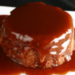 A gluten free sticky toffee pudding with whiskey toffee sauce over it.