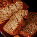 A loaf of gluten free banana bread, along with 2 slices cut from it.