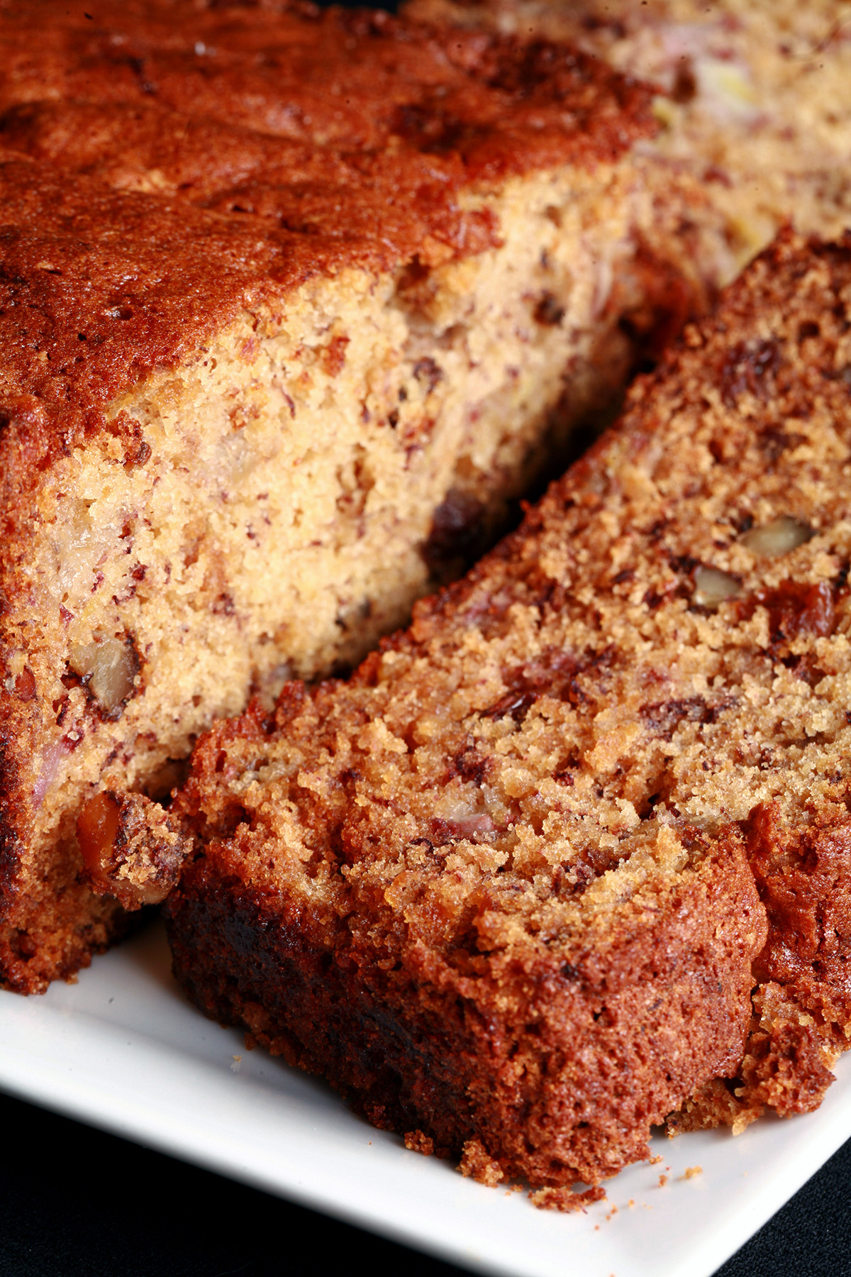 A loaf of easy gluten free banana bread with a slice cut from it.