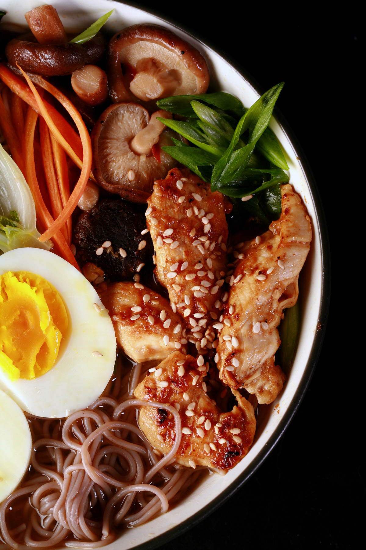 A bowl of gluten free ramen, with chicken and vegetables.
