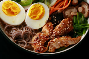 A bowl of gluten free ramen, with chicken and vegetables.