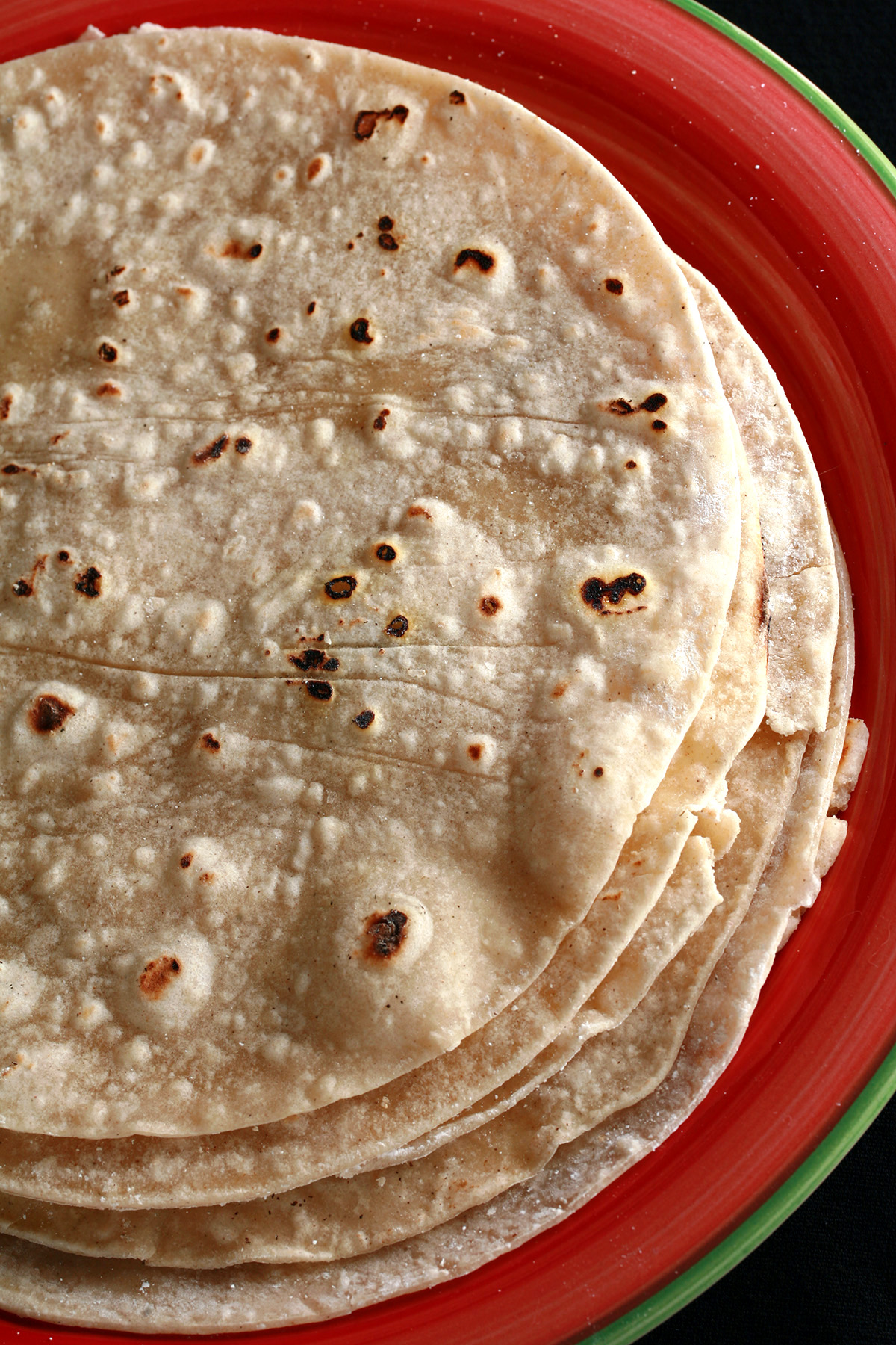A stack of gluten free tortillas on a red plate.
