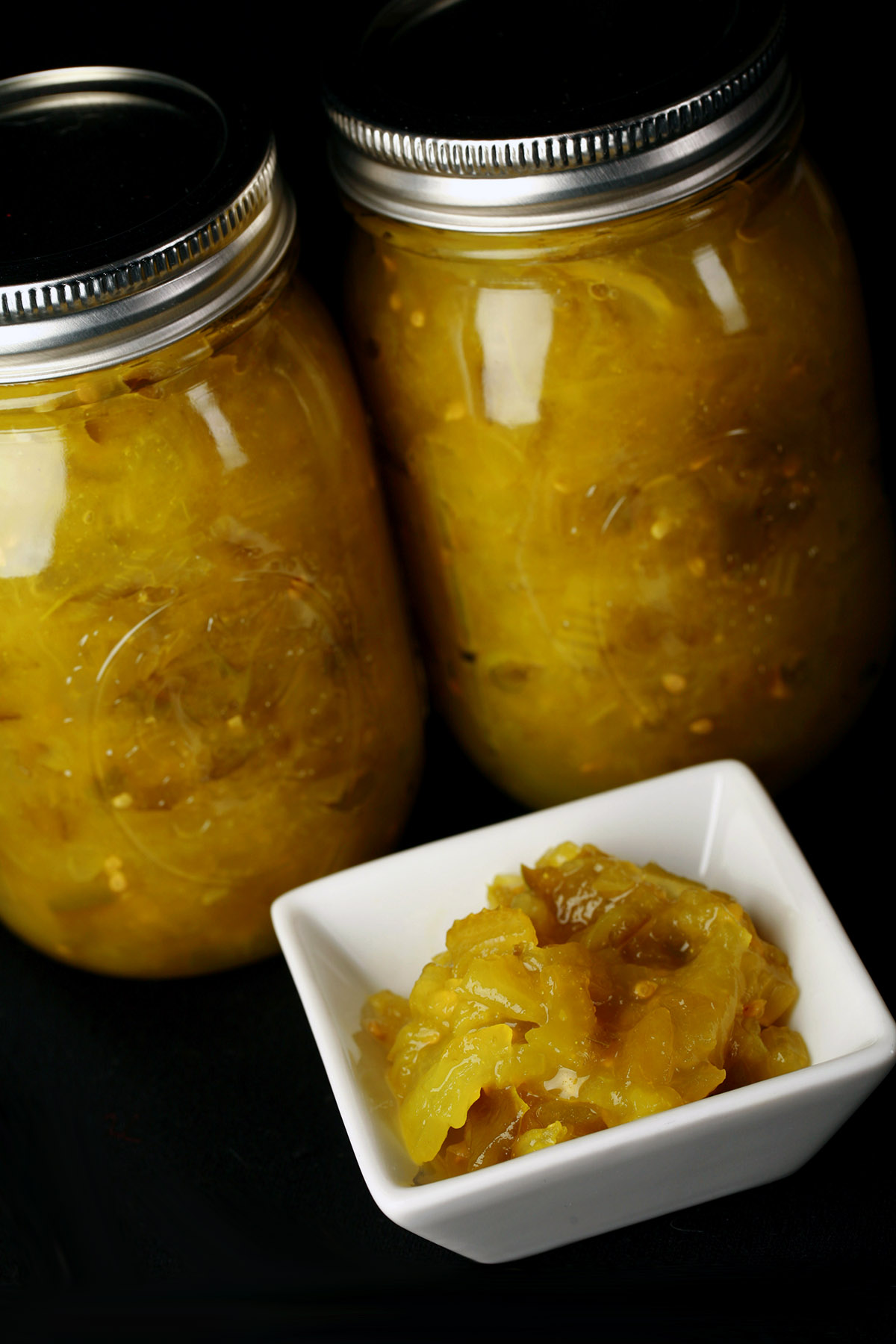 Two jars of chow chow relish, with a little square bowl of the relish in front of them.