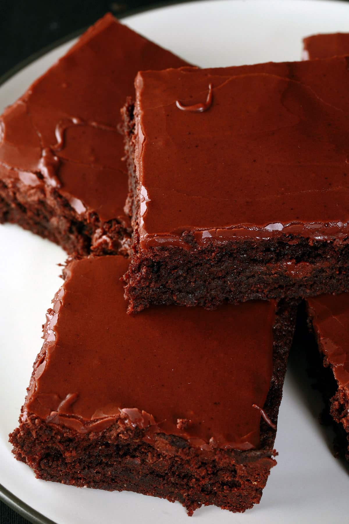 A plate of gluten free brownies with chocolate glaze.