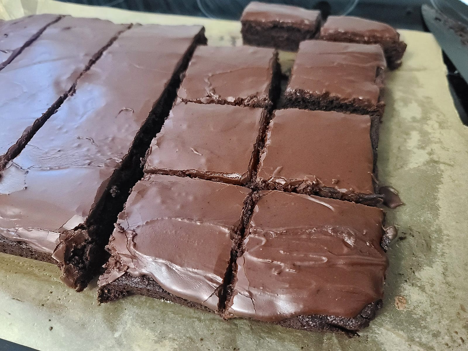 A slab of brownie being cut into squares.