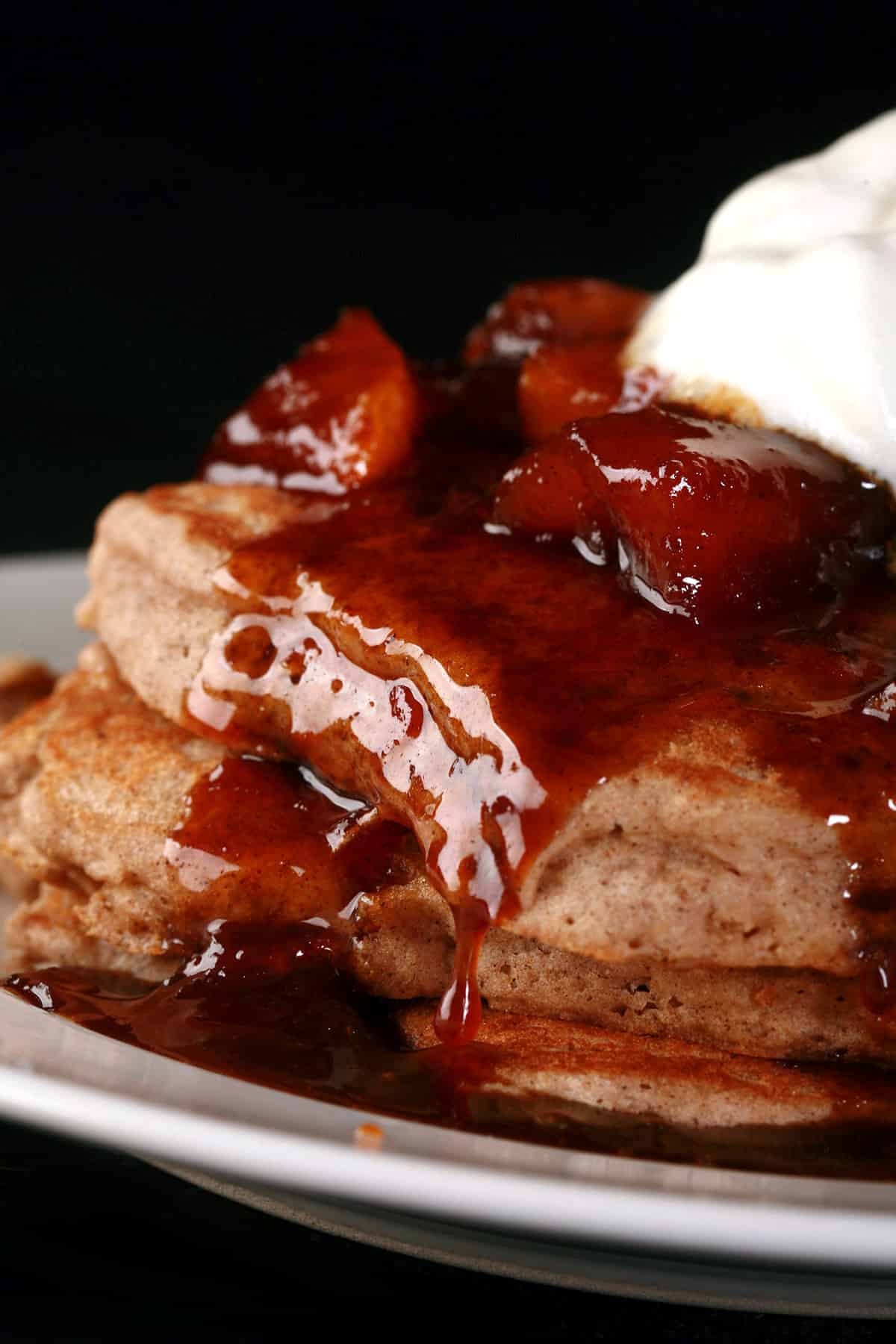 A stack of gluten-free apple pancakes with caramel apple topping.