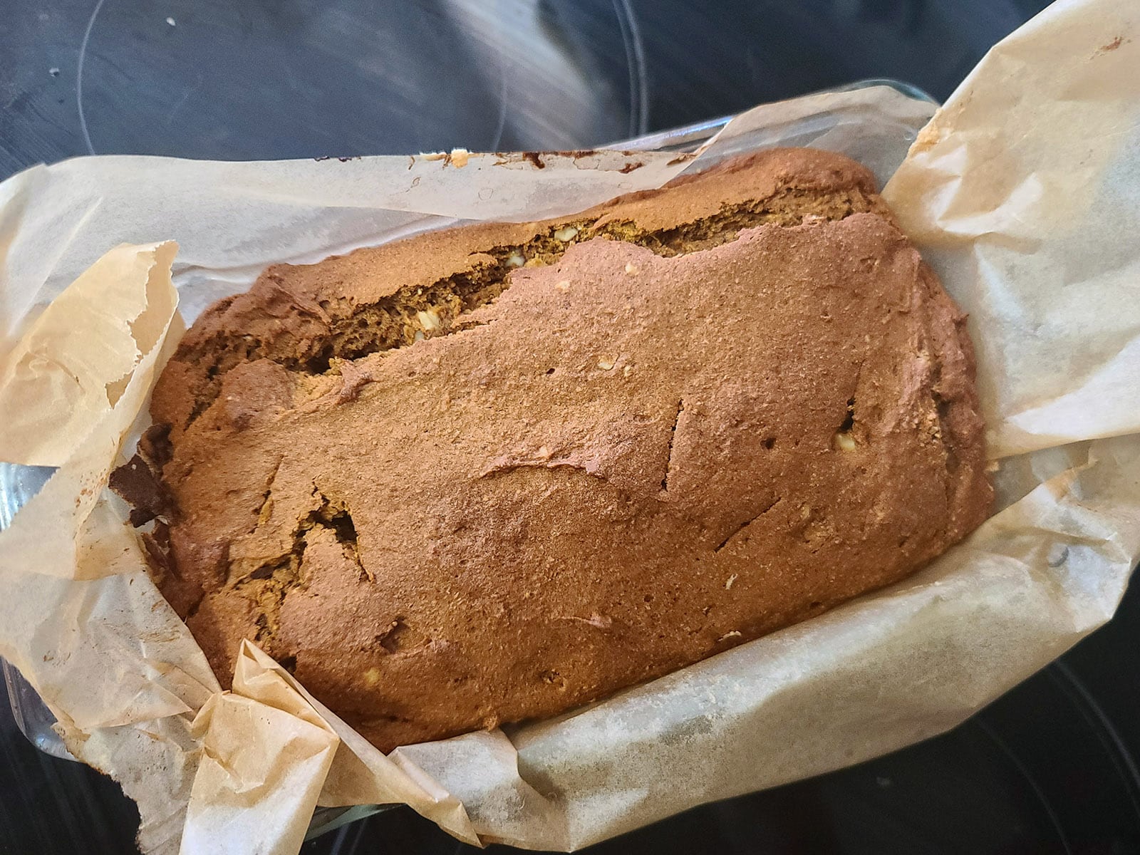 A freshly baked loaf of gluten free pumpkin bread, still in the pan.