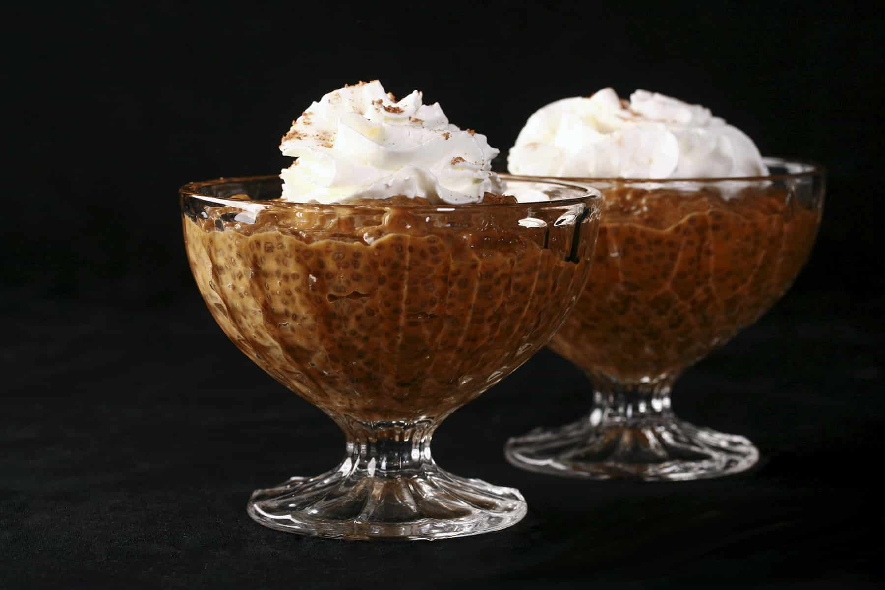 Pumpkin Pie Chia Seed Pudding in a glass cup, topped with whipped cream and nutmeg.