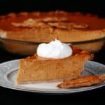 A slice of gluten-free pumpkin pie topped with maple whipped cream.