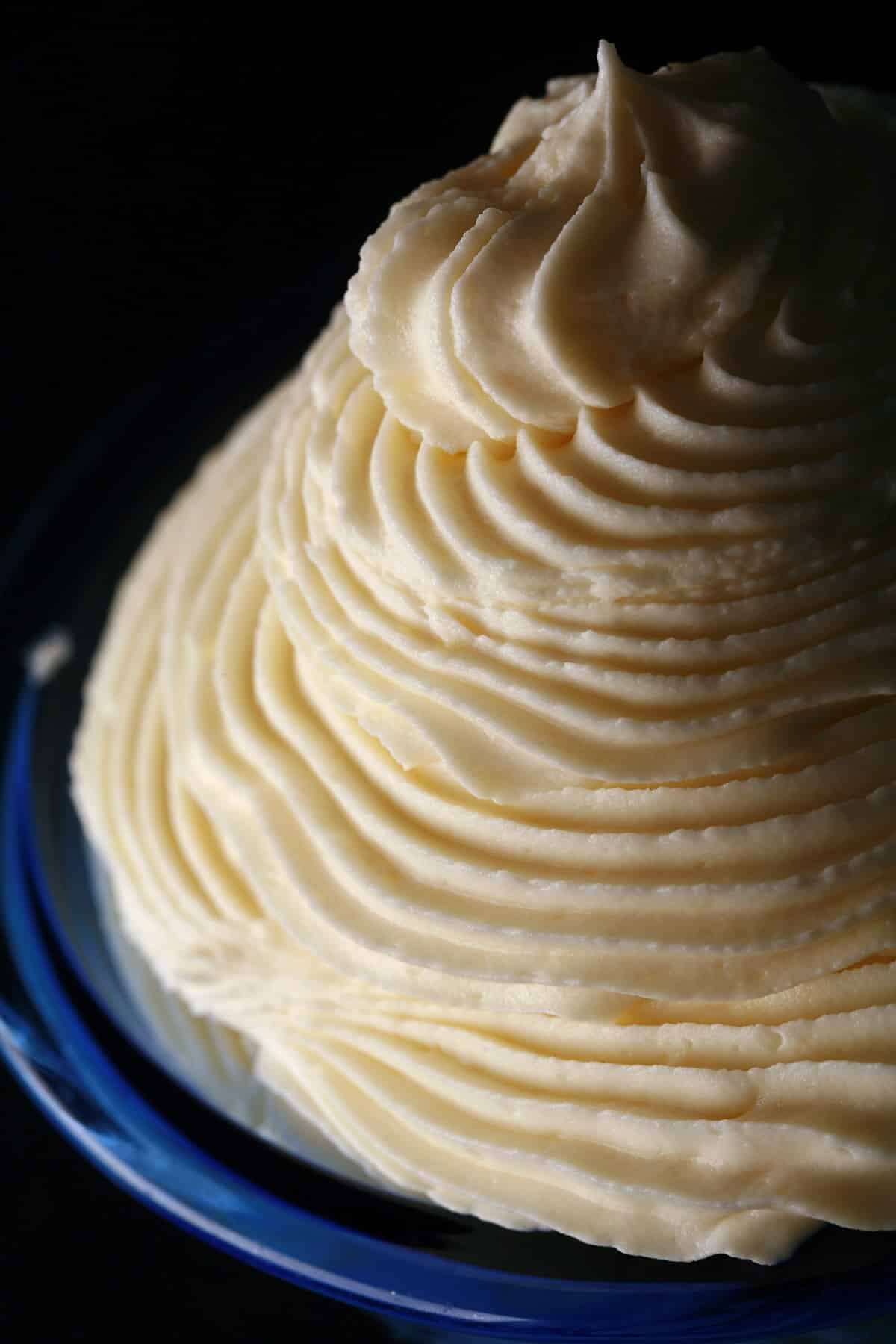 A tall swirl of whipped white chocolate ganache in a small bowl.