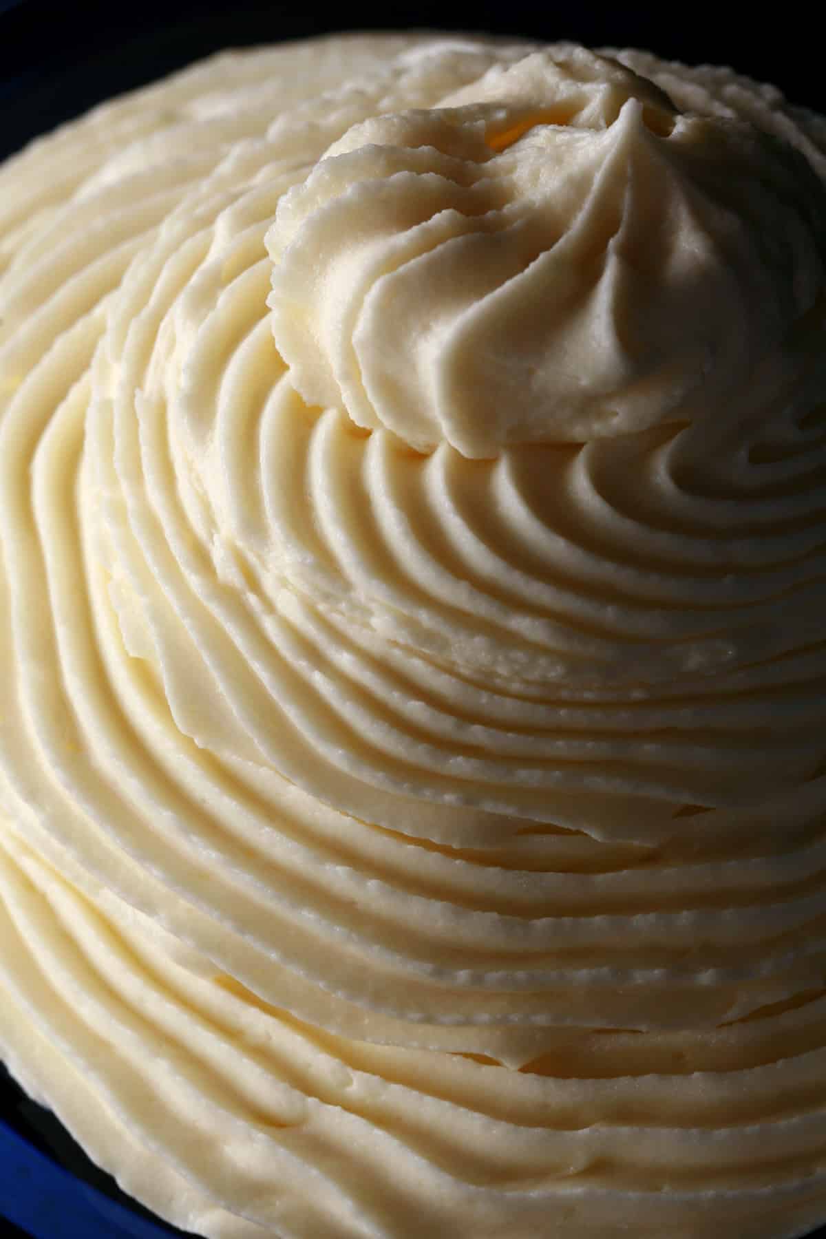 A tall swirl of white chocolate whipped ganache in a small bowl.