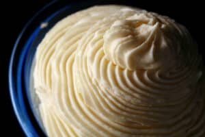 A tall swirl of whipped whiite chocolate ganache in a small bowl.