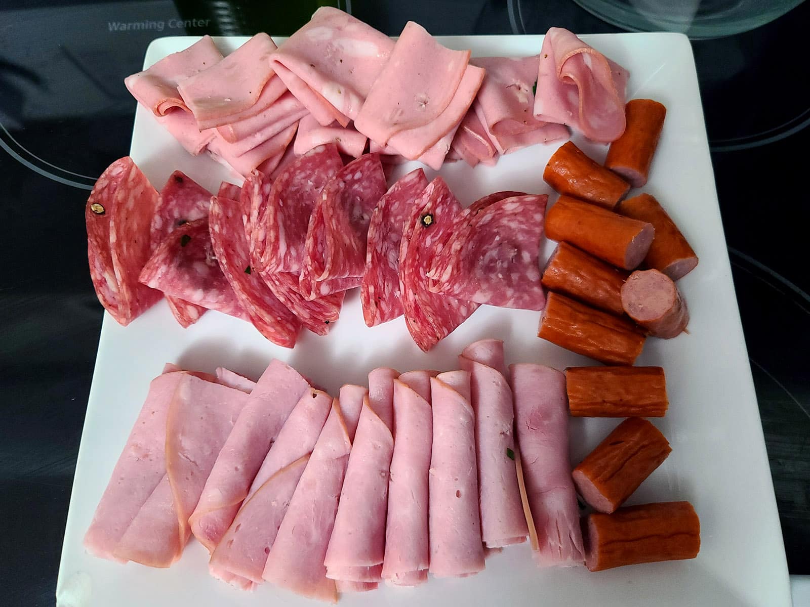 The prepared deli meats on a cutting board.