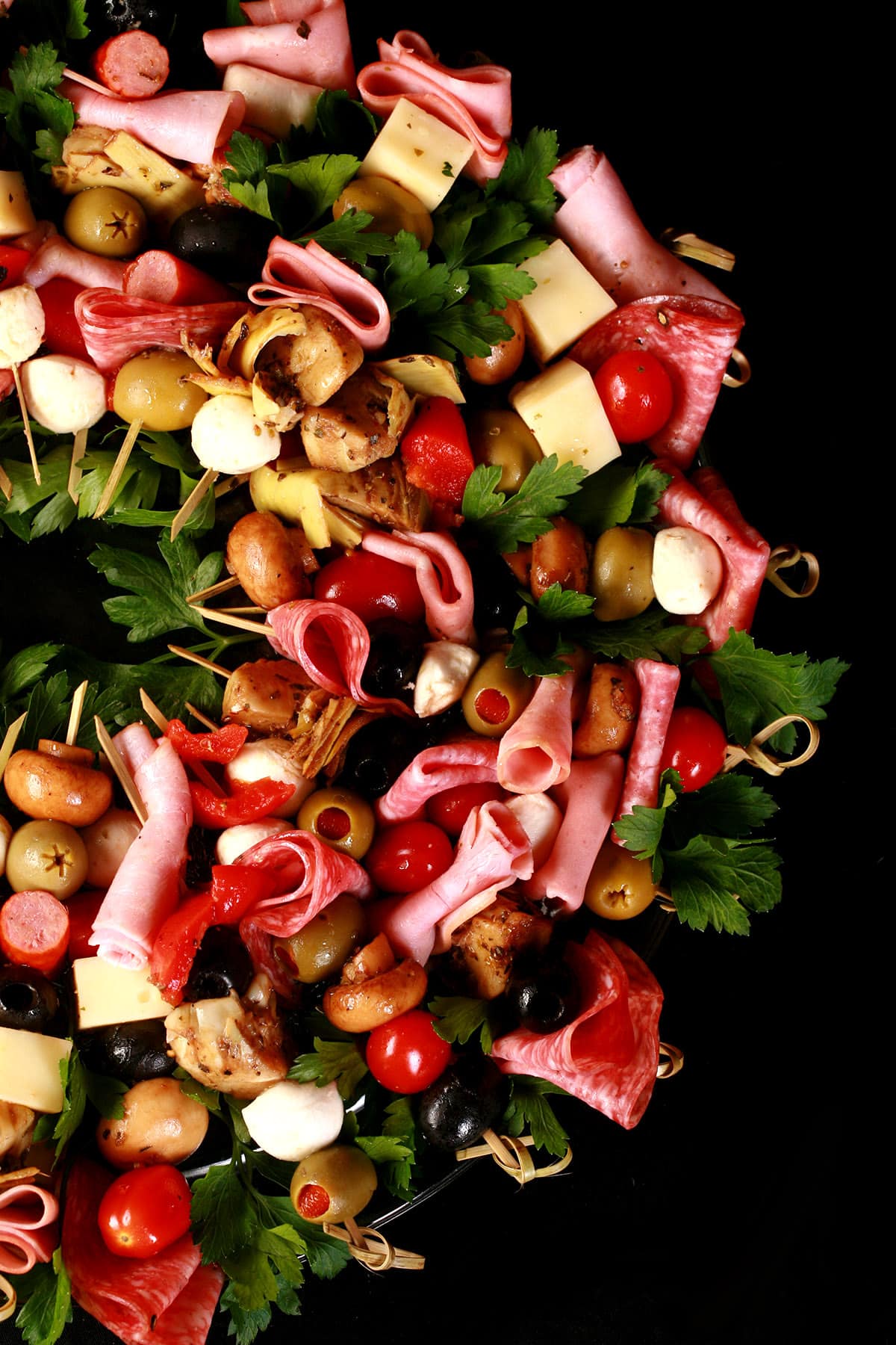 A charcuterie wreath, made up of antipasto skewers featuring various meats, cheeses, and olives.