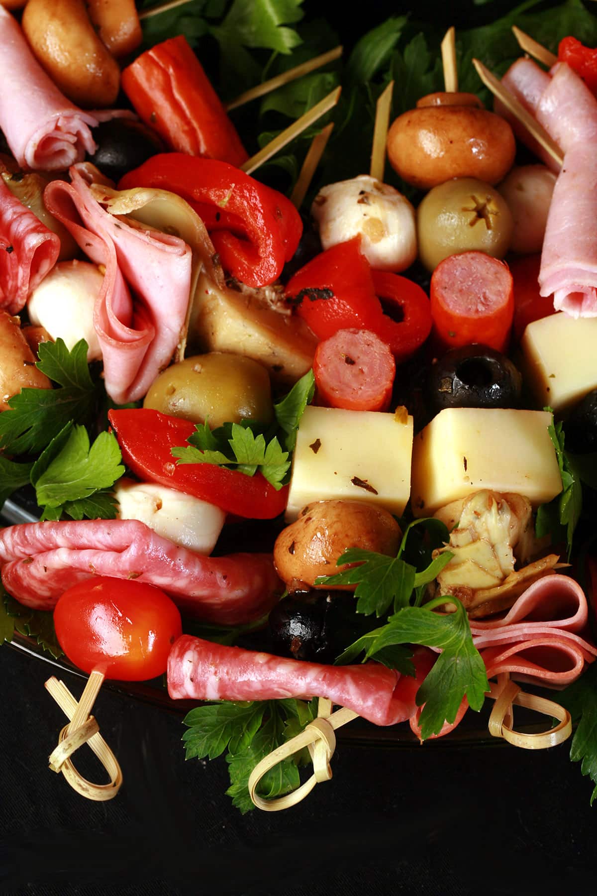 A charcuterie wreath, made up of antipasto skewers featuring various meats, cheeses, and olives.