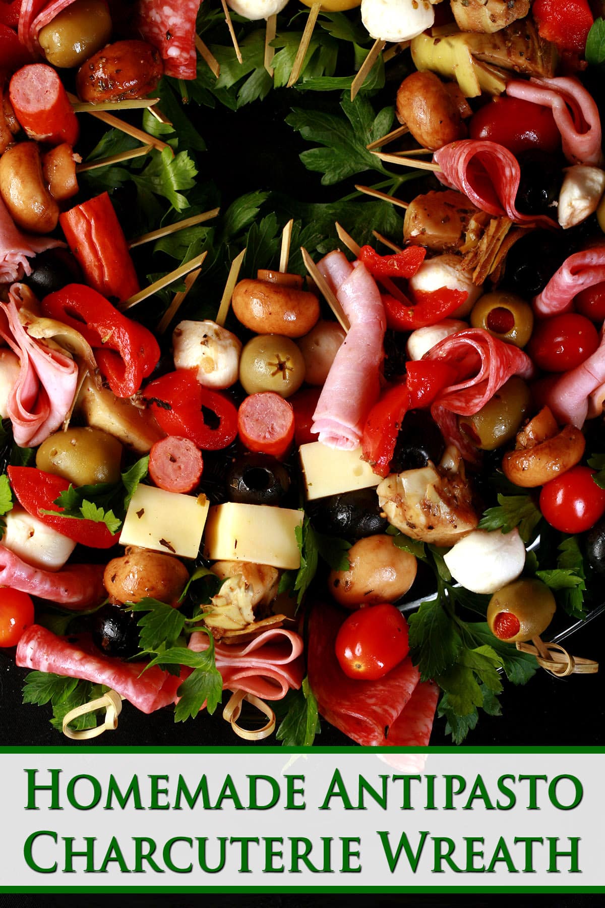 A wreath shaped charcuterie board, made up of antipasto skewers featuring various meats, cheeses, and olives.  Green text says homemade antipasto charcuterie wreath.