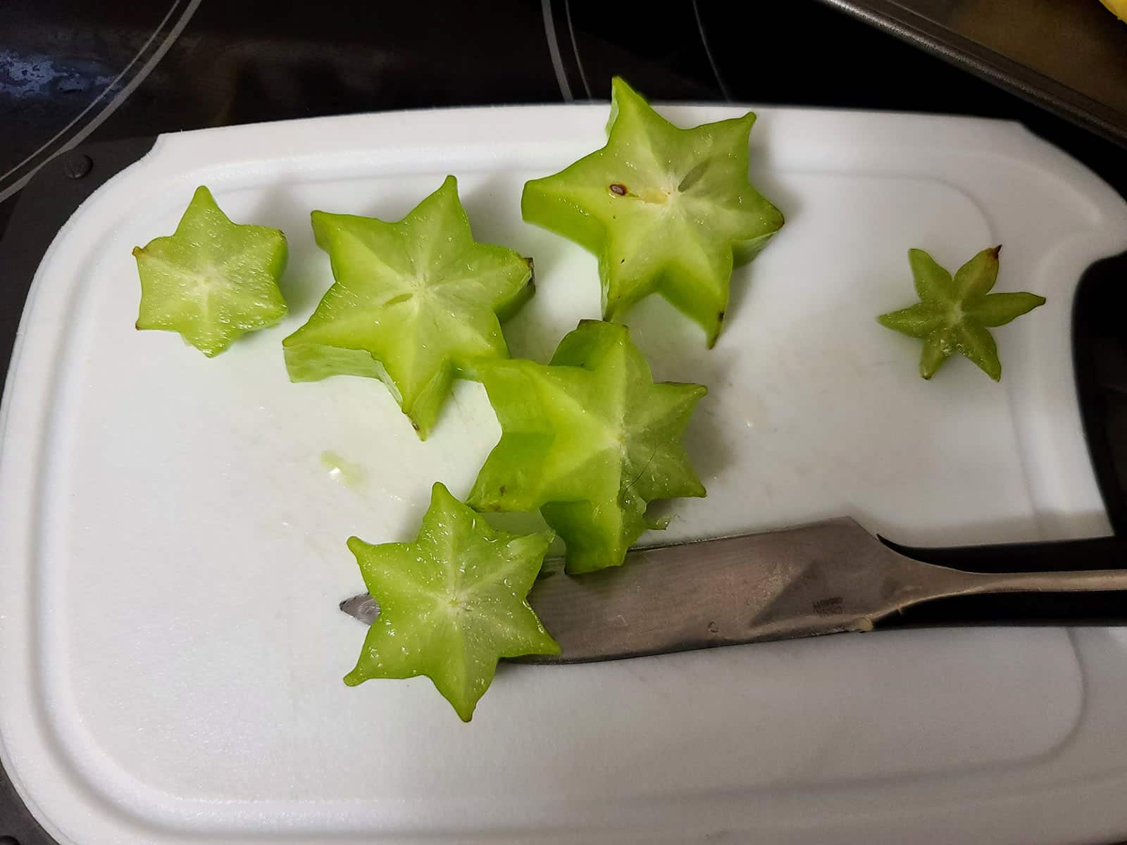 A sliced up star fruit on a cutting board.