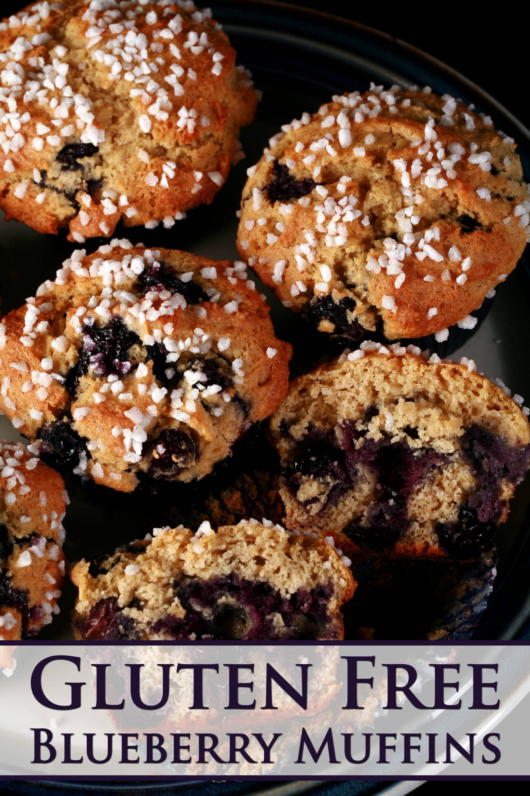 Several sugar topped gluten-free blueberry muffins on a plate.