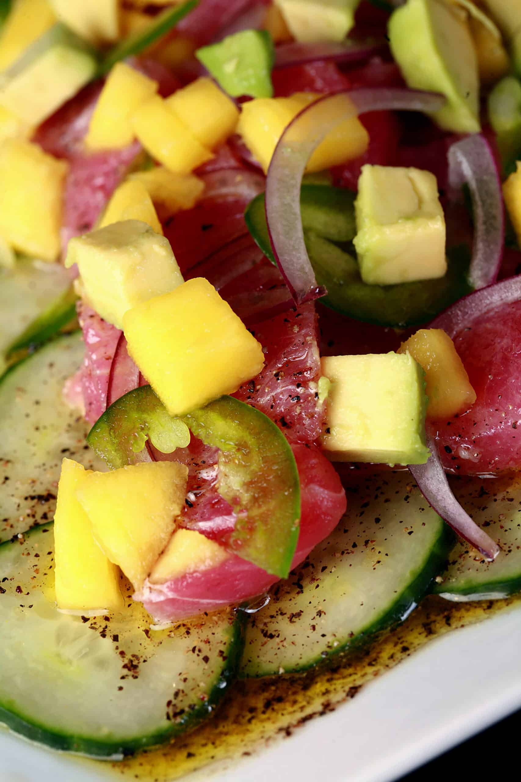 A close up photo of ahi tuna crudo, with mango, avocado, jalapenos, and a citrus vinaigrette.