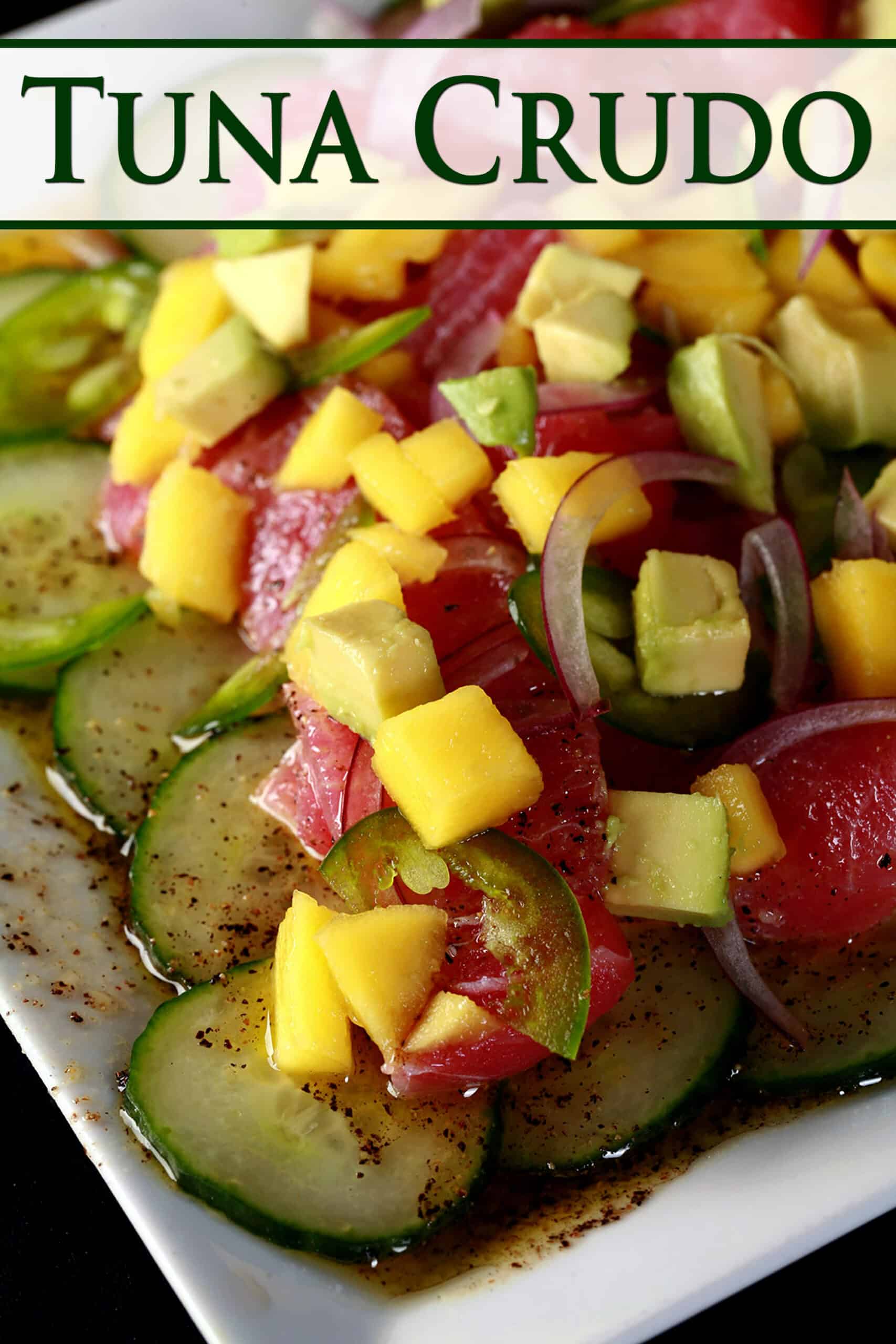 A close up photo of ahi tuna crudo, with mango, avocado, jalapenos, and a citrus vinaigrette, served over cucumber slices.