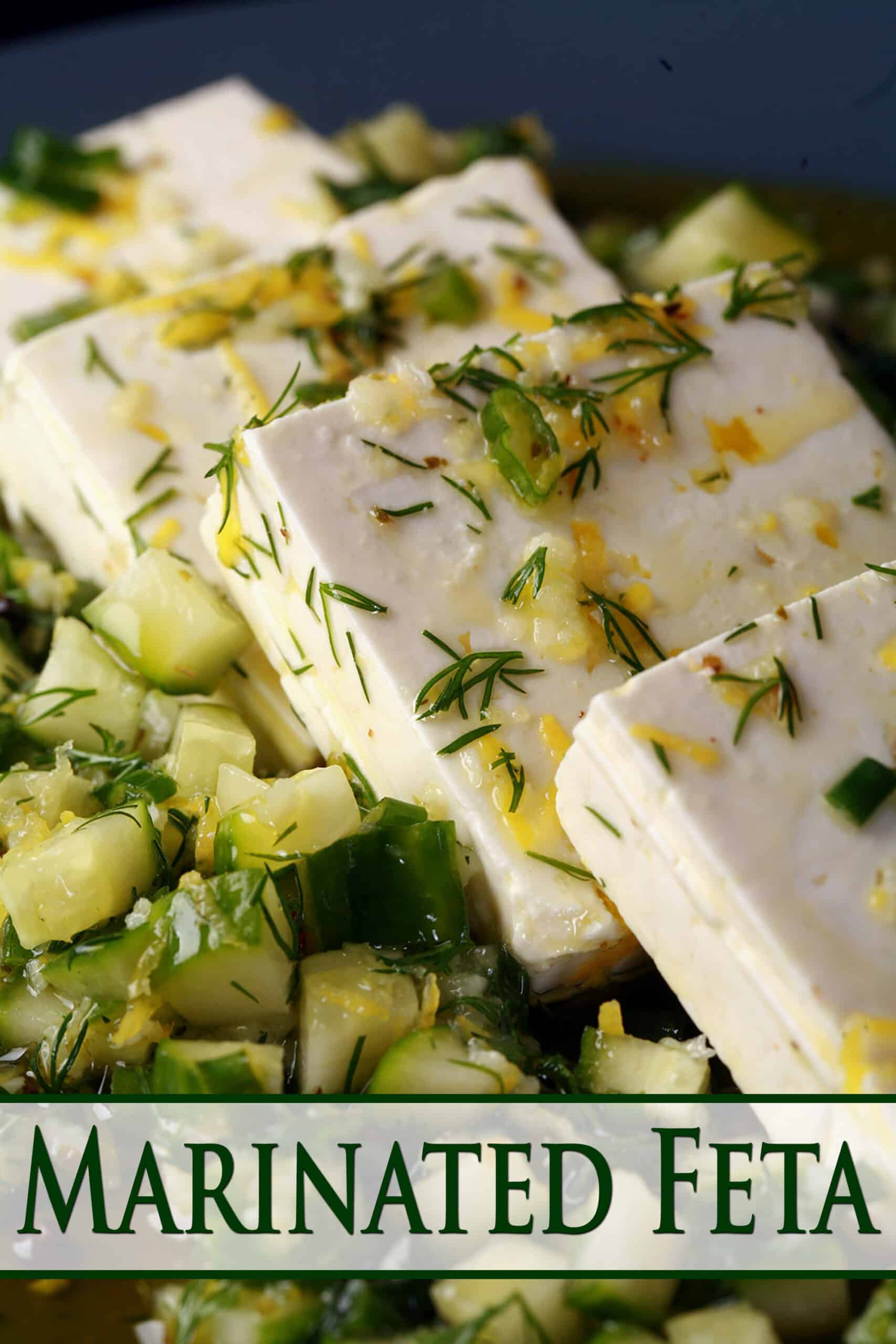 4 slices of lemon herb marinated feta cheese on a bed of marinated cucumber.