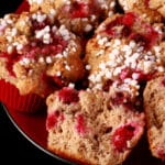 1 plate of gluten-free cranberry muffins with walnuts and a sugar crust on top.