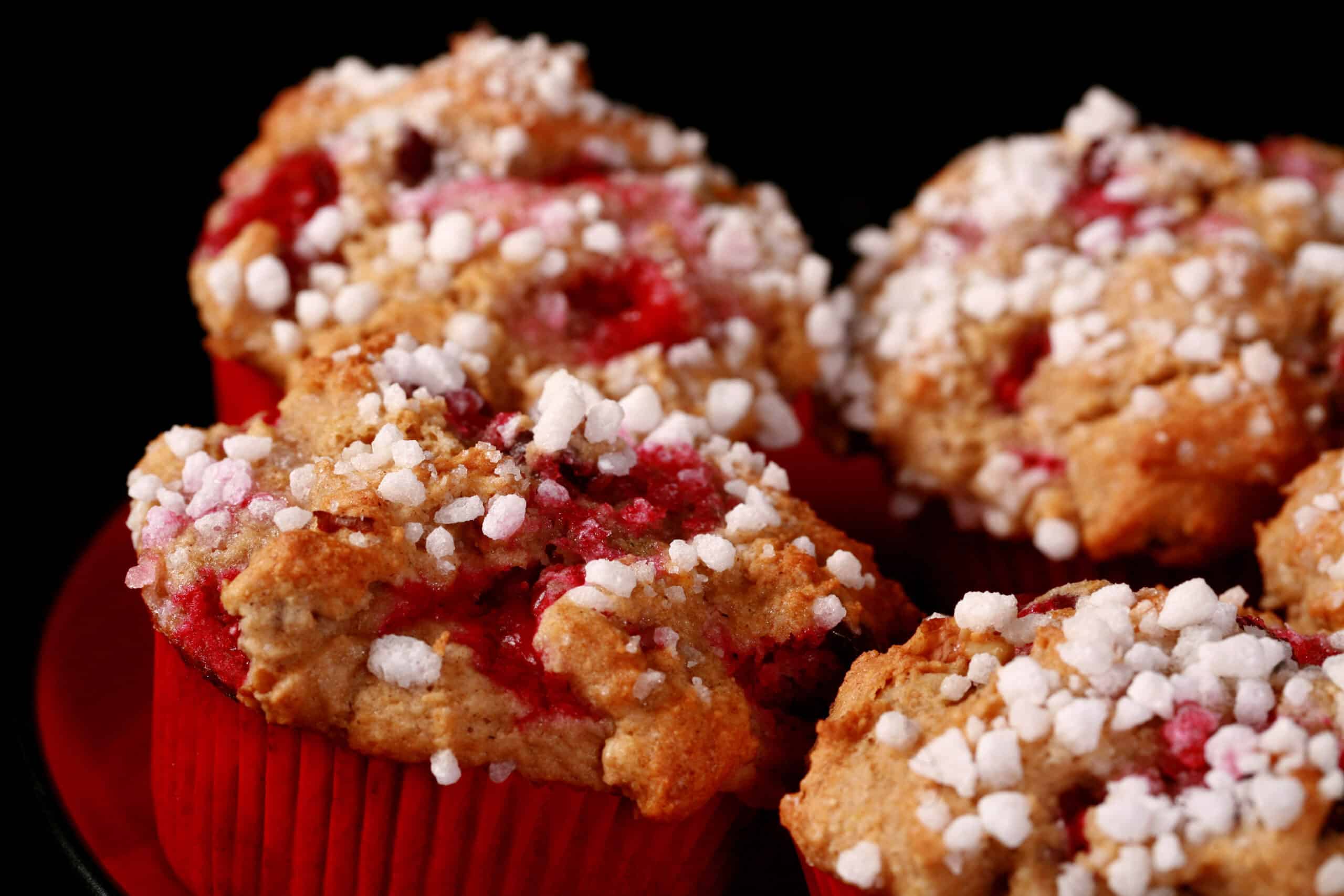 1 plate of gluten-free cranberry walnut muffins with sugar crust on top.