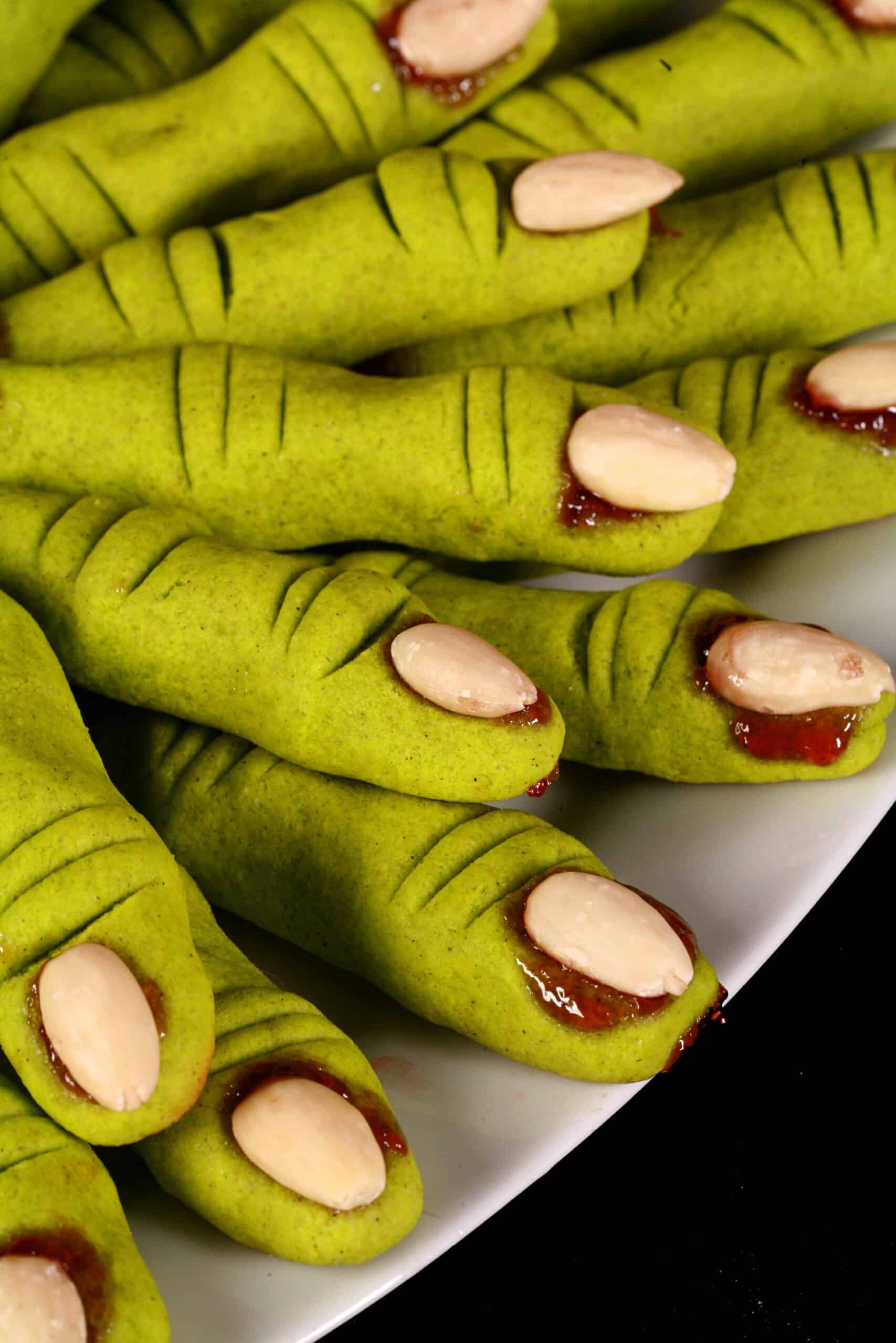 A plate of bright green gluten free witch finger cookies.