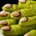 A plate of bright green gluten-free witches' finger cookies.