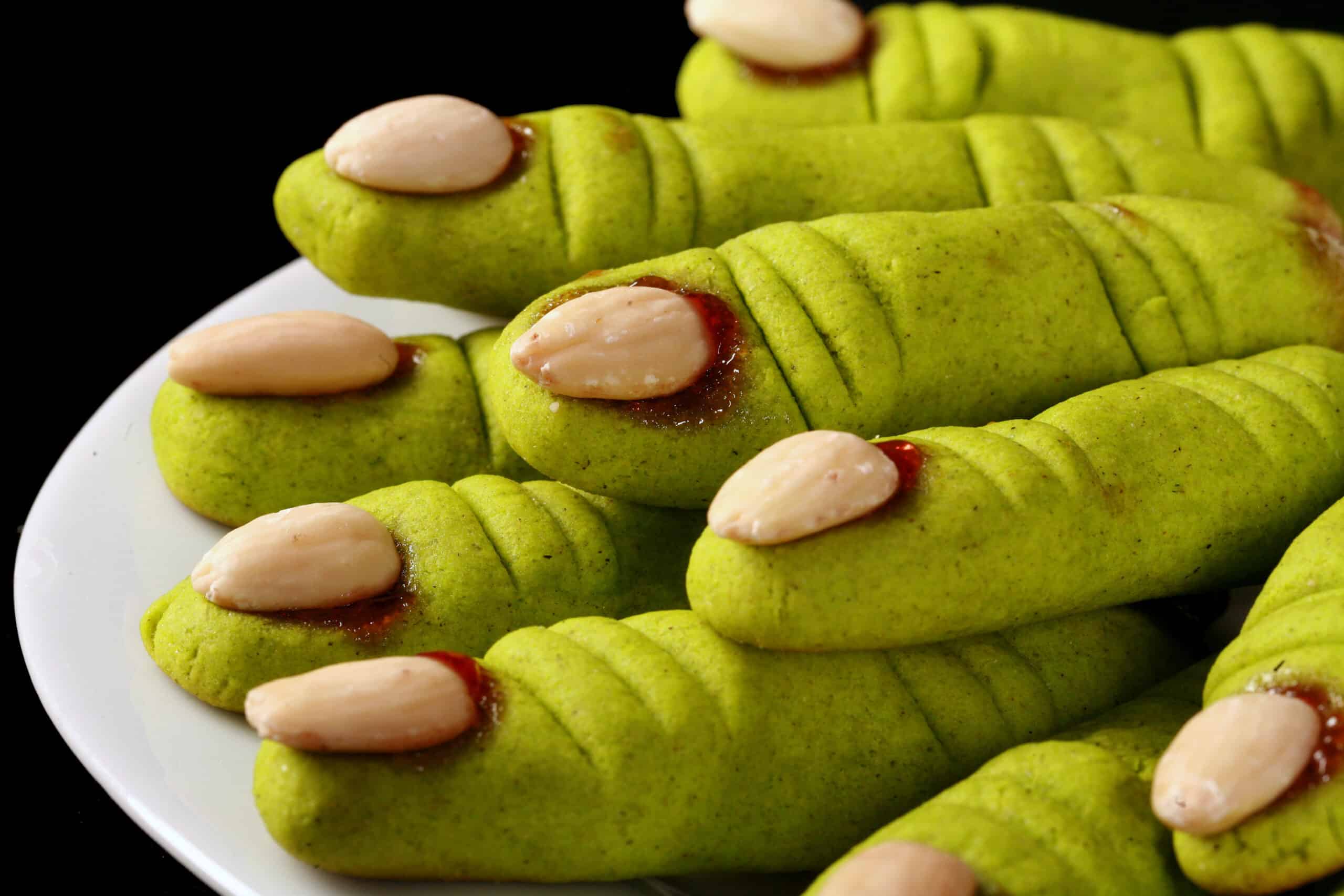 A plate of bright green gluten-free witches’ finger cookies.