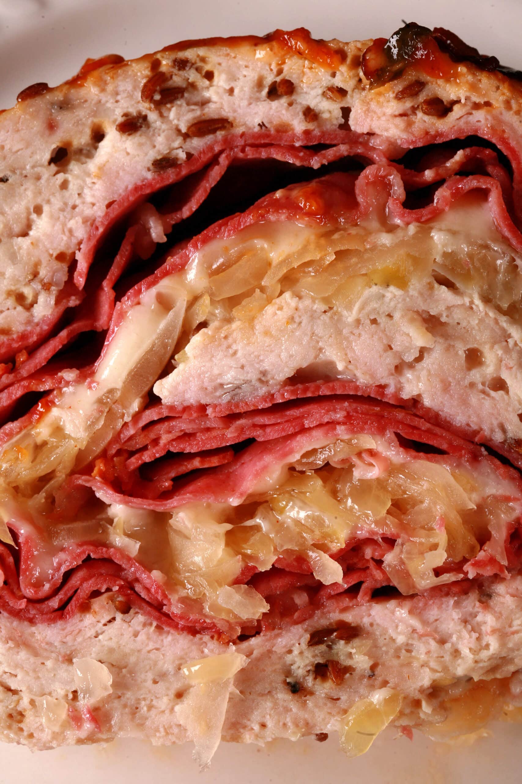 A slice of Reuben stuffed Meatloaf on a plate.