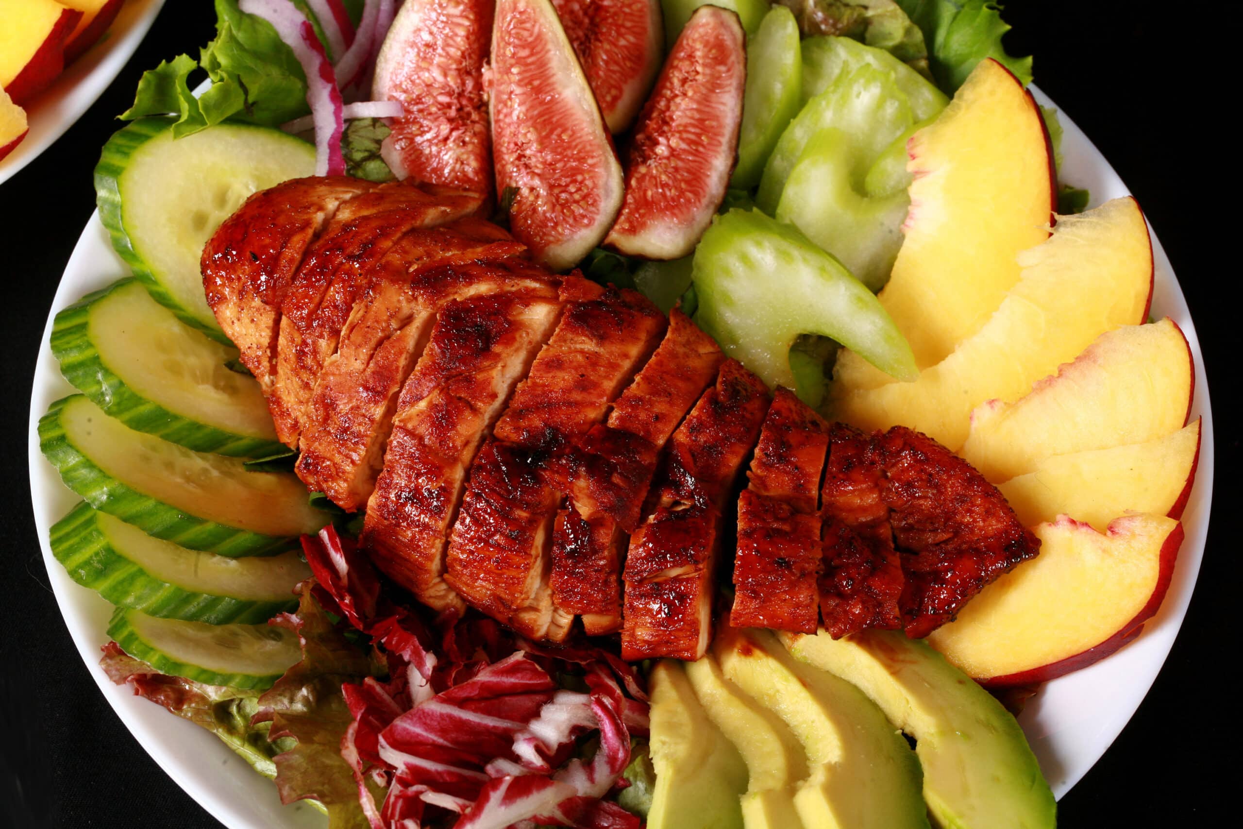 2 balsamic glazed chicken and peach salads, with peaches, figs, avocado, vegetables, and white peach balsamic vinegar glazed  chicken breast.